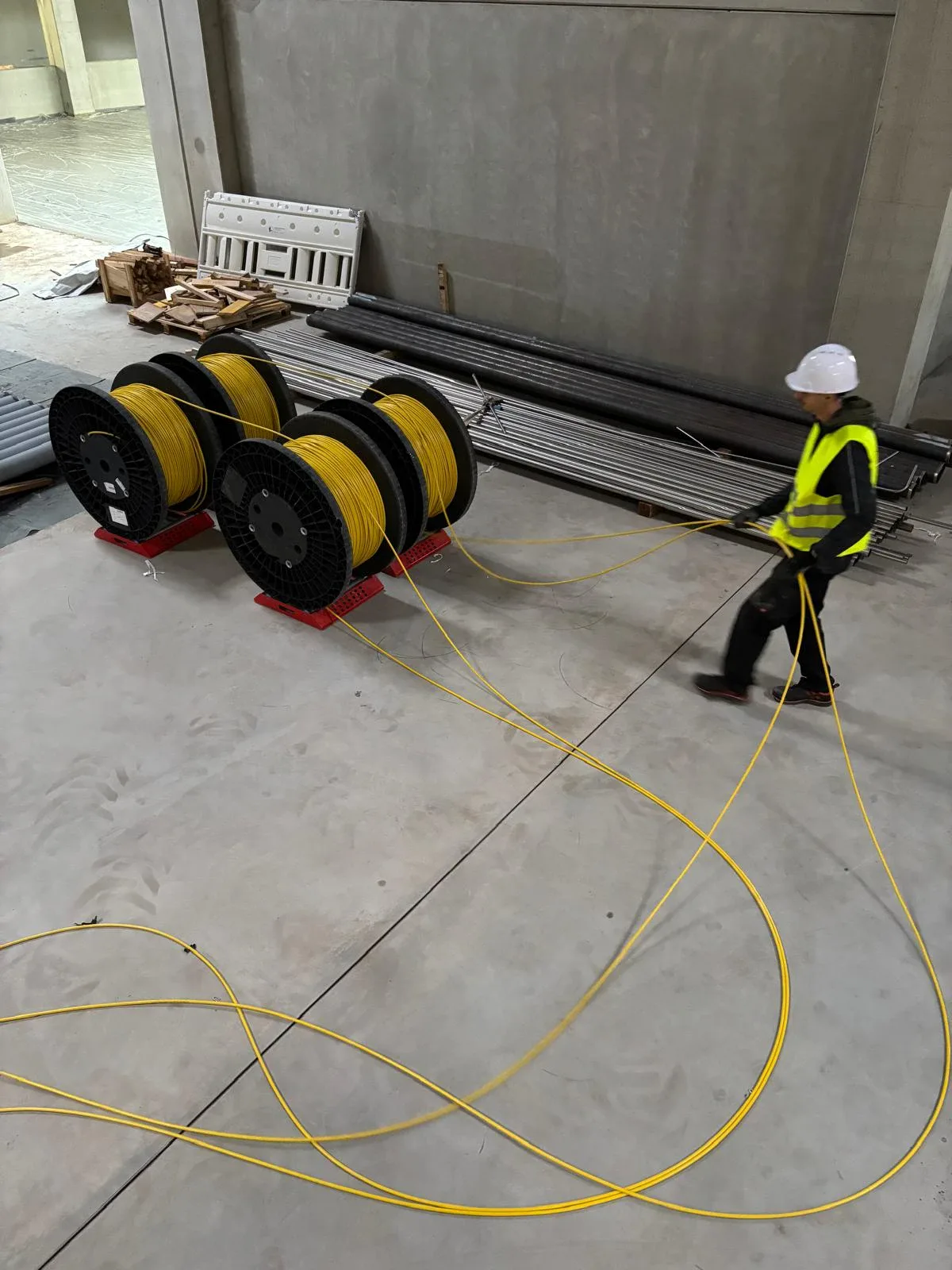 Technician handling fiber cabling on an industrial build site
