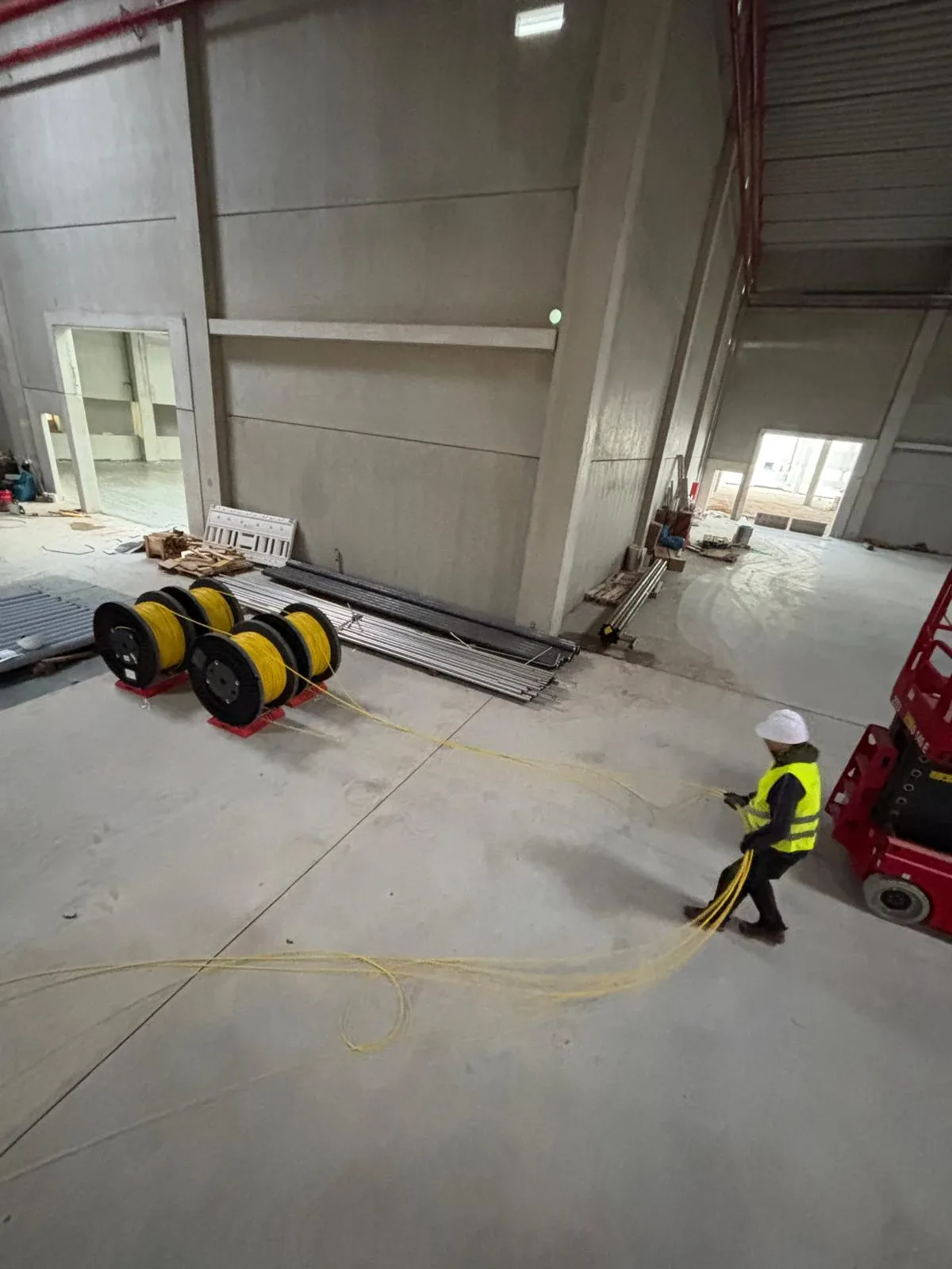 Fiber cabling being routed inside a large industrial hall