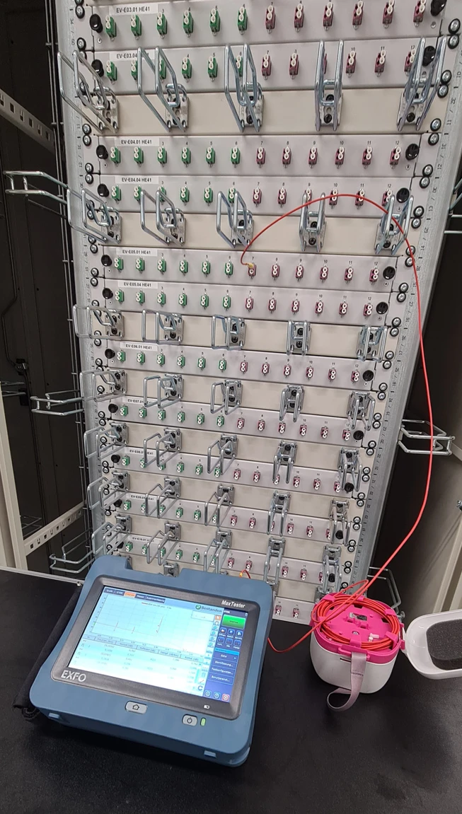 OTDR device connected to a rack during fiber measurement
