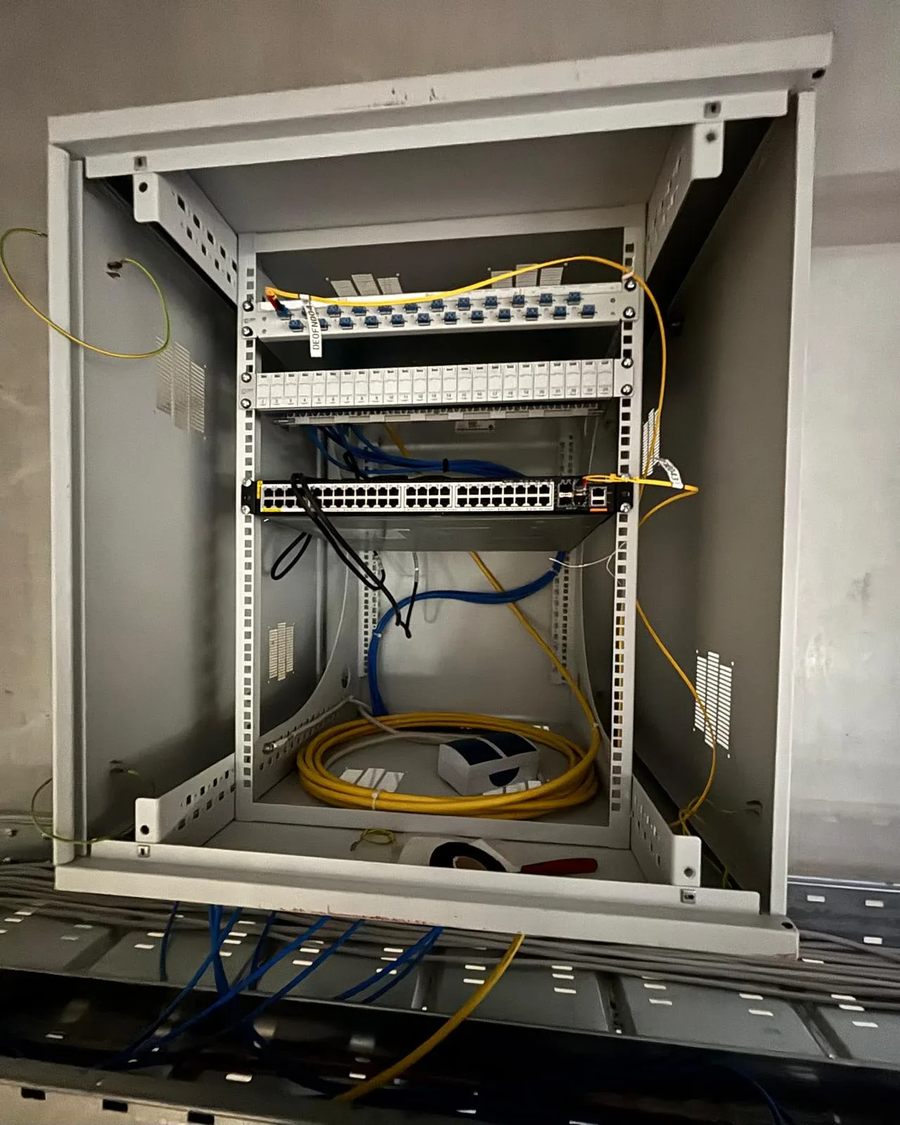 Wall rack with switch, patch panel and cable routing